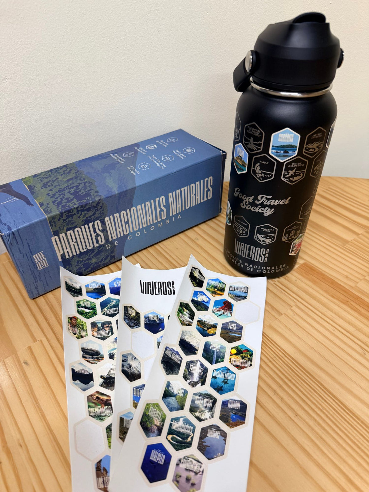 Termo Viajeros DyD con caja y stickers sobre mesa de madera